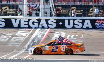 Brad Keselowski does his traditional victory celebration with the American flag. He also celebrated Team Penske's 500th career victory. Photo by Rachel Myers for Speedway Media.