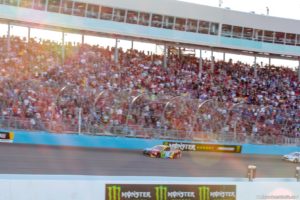The sun sets behind the grandstands as Kyle Busch pulls away to his 51st career NASCAR Monster Energy Cup Series win. Photo by Rachel Schuoler for Speedway Media.